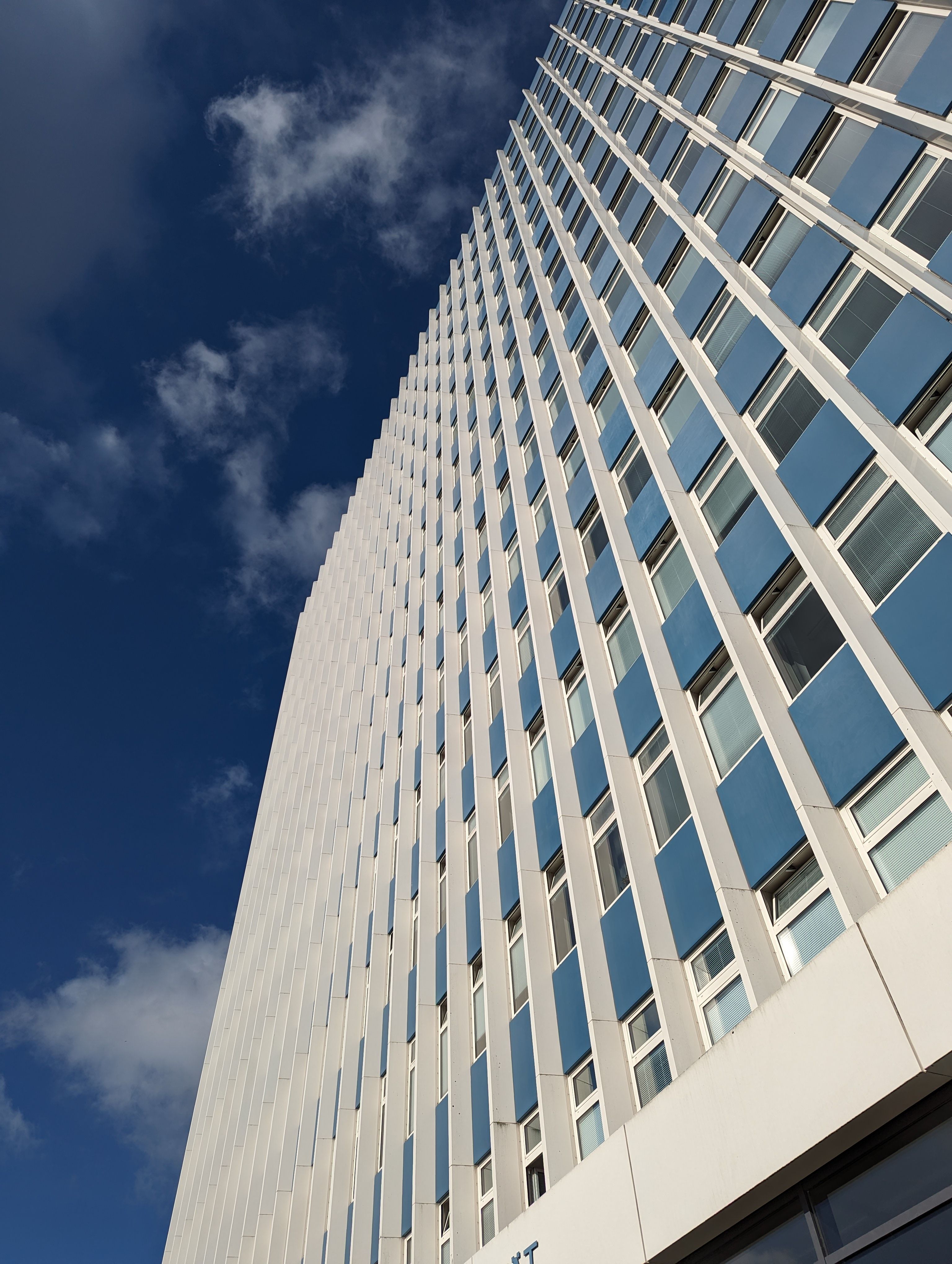 Der Blick von unten auf die Fassade des Uni-Hochhauses bei klarem Himmel